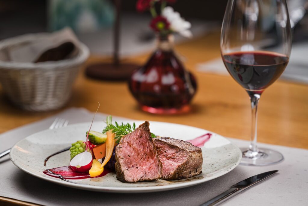 Rindsfilet mit Gemüse und einem Glas Rotwein in der Hofstube